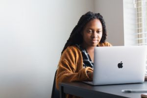 BIPOC woman looking at laptop and being engaged
